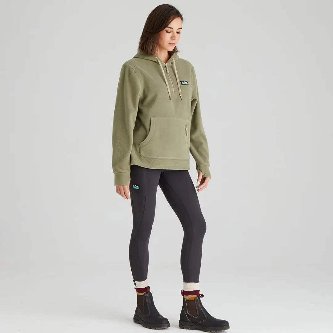 Woman wearing a Ridgeline Womens Ballistic Hoodie with green hoodie and black leggings