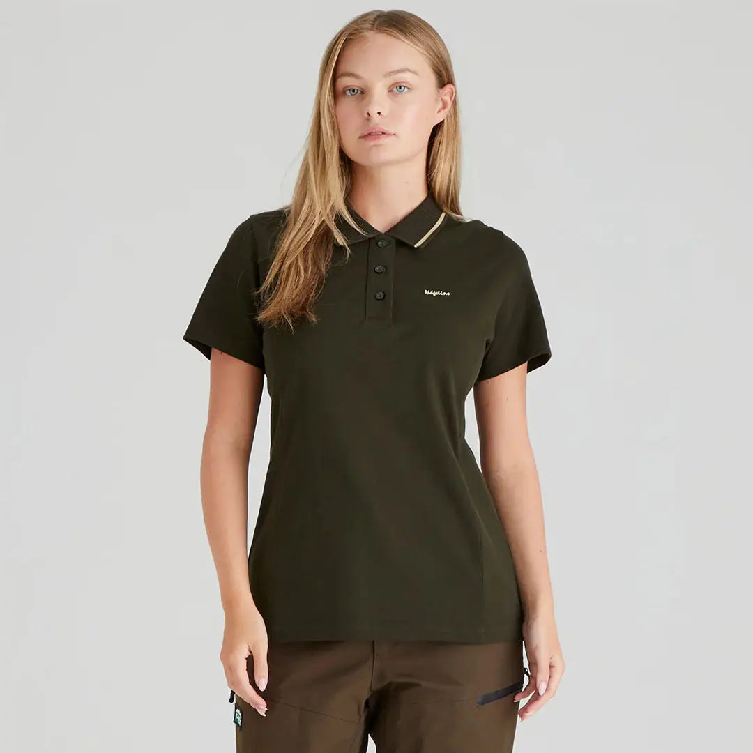 Woman wearing a dark green Ridgeline Womens Kilworth Polo Shirt, perfect for casual wear