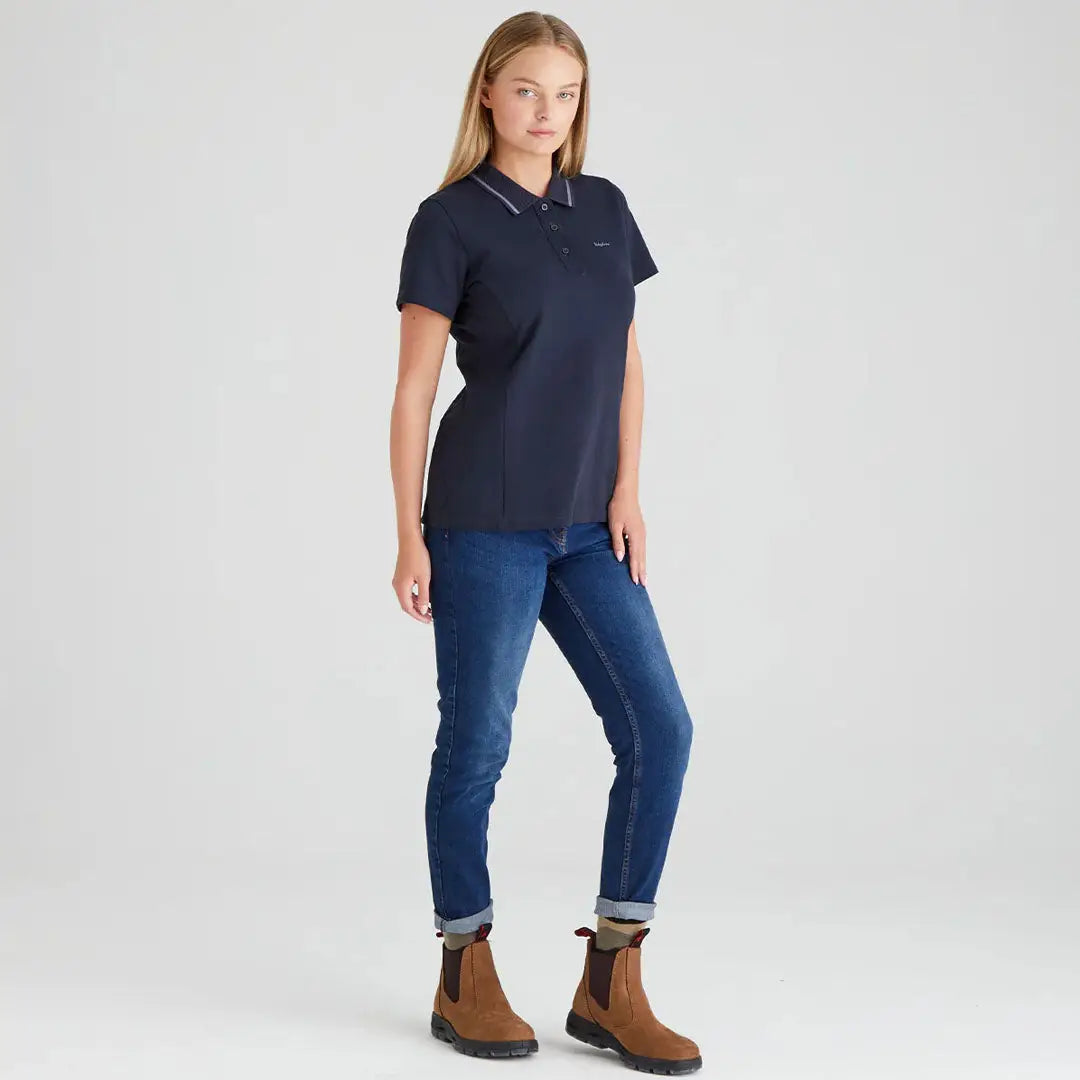 Woman wearing a navy Ridgeline Womens Kilworth Polo Shirt with jeans and brown boots