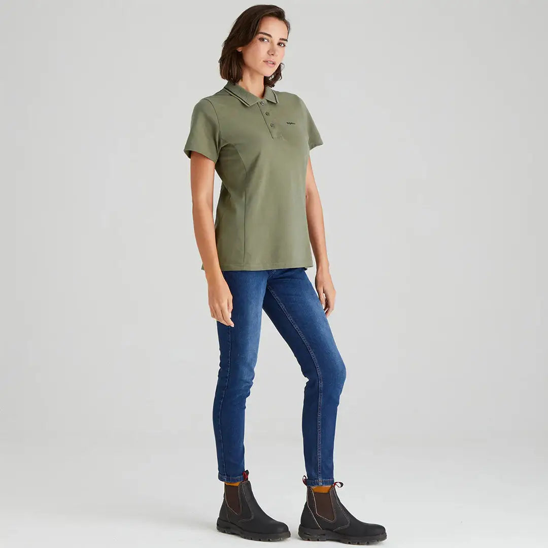 Woman wearing Ridgeline Womens Kilworth Polo Shirt in green and blue jeans