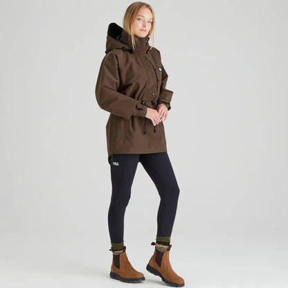 Woman in brown hooded parka with black leggings and boots from Ridgeline Womens Monsoon Classic Smock