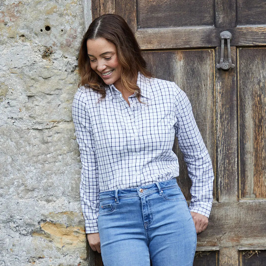 Woman in a checkered shirt and jeans wearing the Ridgeline Womens Sedgebrook Shirt