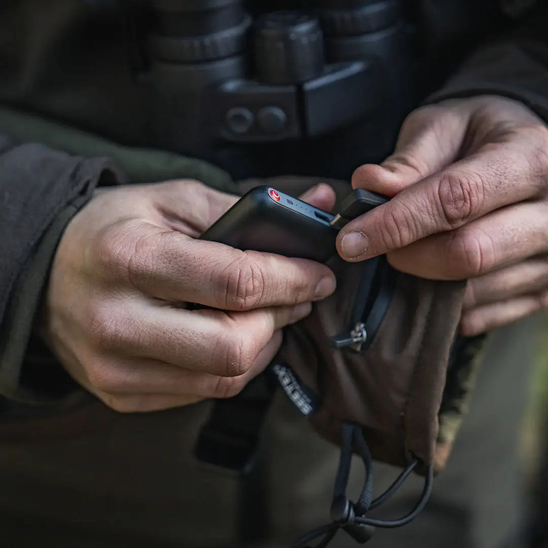 Person holding a black power bank with Seeland Celsius Heat Gloves for heat on the go