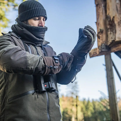 Man in winter gear putting on Seeland Celsius Heat Gloves, cold weather heat gloves