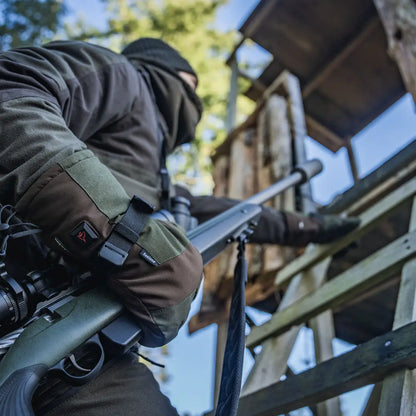 Hunter climbing with rifle wearing Seeland Celsius Heat Gloves for cold weather warmth