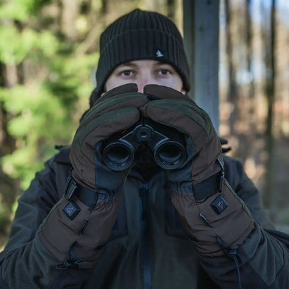 Person holding binoculars with gloved hands wearing Seeland Celsius Heat Gloves for warmth