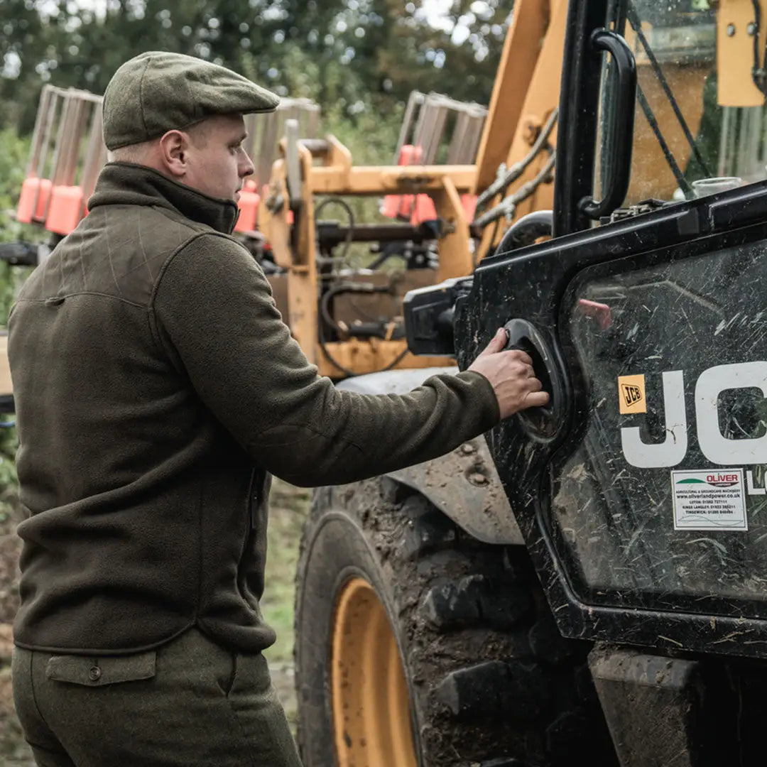 Man fueling construction gear wearing Seeland Fog Fleece Jacket, perfect for country clothing and hunting