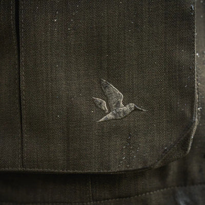 Dark herringbone fabric with bird emblem on Seeland Highpoint Jacket, perfect for country hunting gear