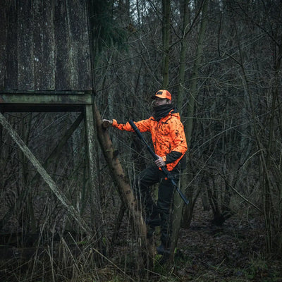 Hunter climbing tree with rifle wearing Seeland Iron Neckgaiter for outdoor gear protection