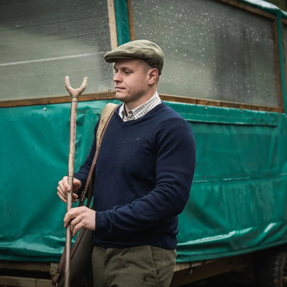 Man in tweed cap holding shooting stick wearing Seeland Pine V-Neck Pullover for hunting