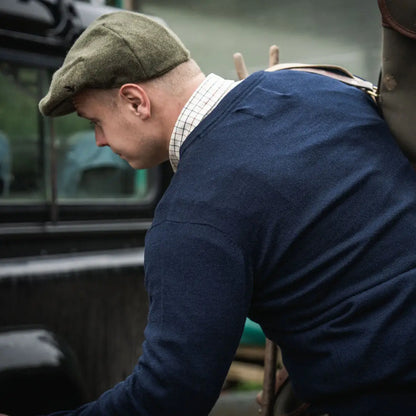 Man in tweed cap and blue pine V-Neck pullover, perfect for country clothing and hunting