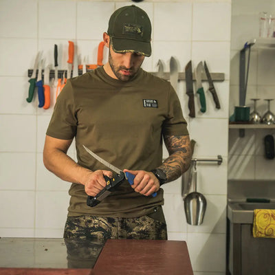 Man sharpening a knife in Seeland Striker T-Shirt, perfect for country clothing and hunting