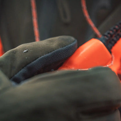 Green glove holding an orange target for hunting with Seeland Target Gloves