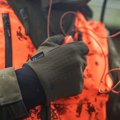 Gloved hand holding Seeland target gloves, perfect for hunting country clothing
