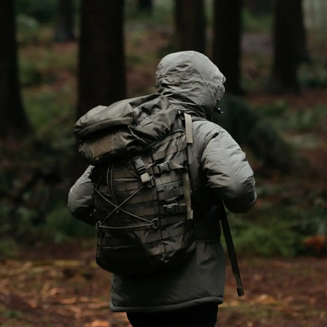 Person in a jacket and backpack exploring a forest with Snugpak Endurance 40L Rucksack