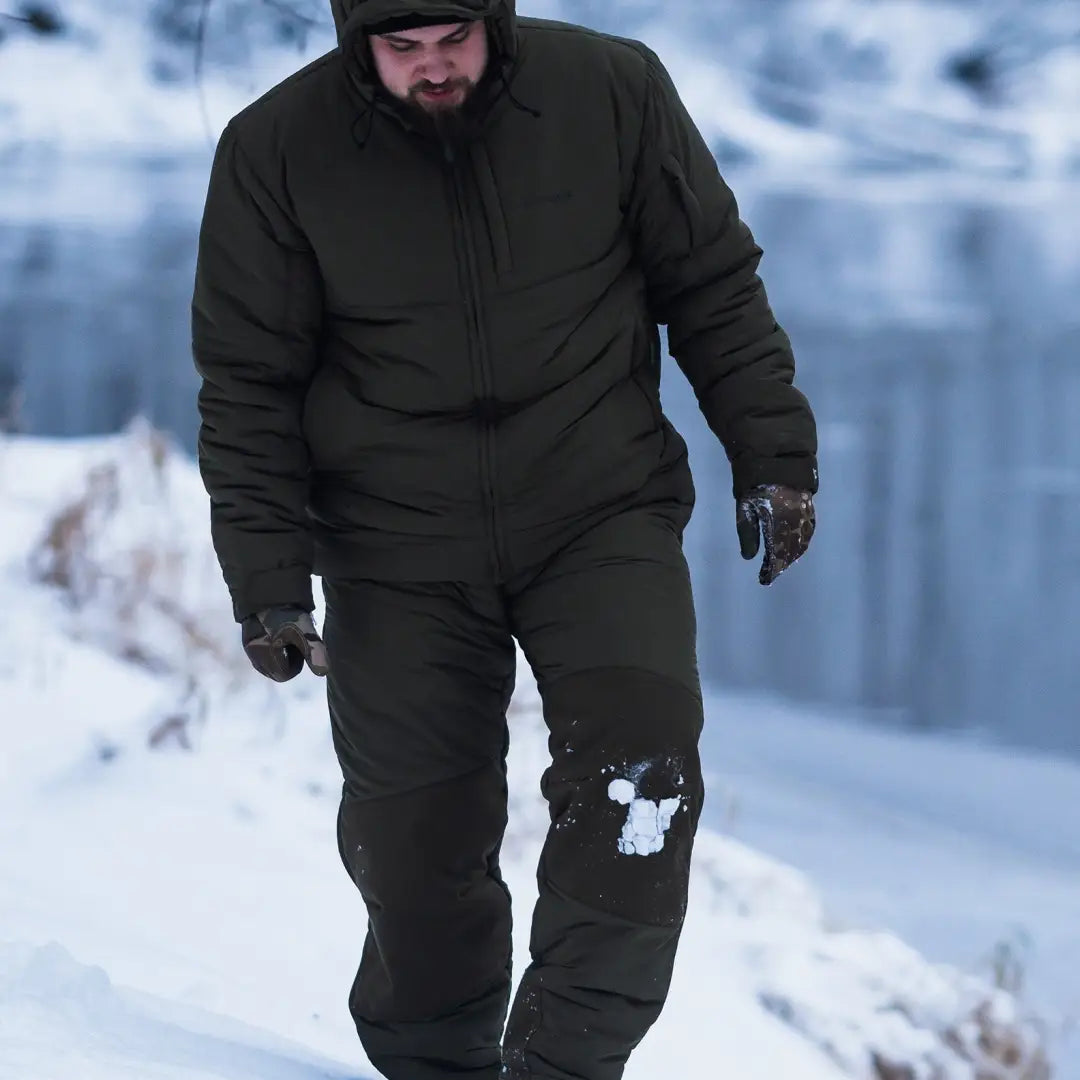 Person in dark green Parallax Insulated Pants walking through snow comfortably