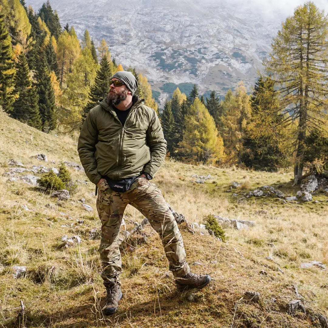 Hiker in Snugpak Spearhead Technical Midweight Insulated Jacket on a grassy mountain