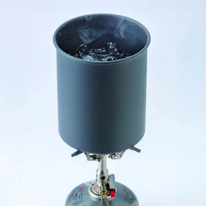 Boiling water in a gray Soto Thermolite Pot on a camping stove with storage pouch