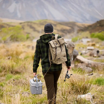 Person with Swanndri Arrowtown backpack fishing in a grassy field for country hunting gear