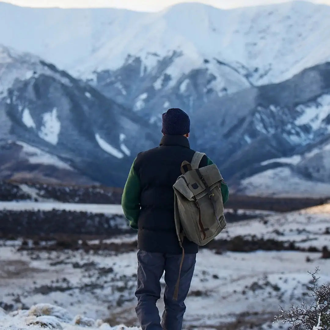 Man with Swanndri Arrowtown backpack in winter country clothing facing snowy mountains