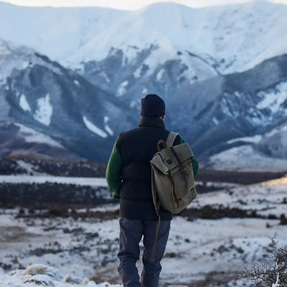 Man with Swanndri Arrowtown backpack in winter country clothing facing snowy mountains