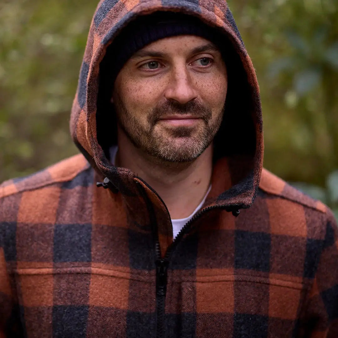 Man wearing a hooded orange and black plaid Swanndri Hudson Wool Hoody with beanie