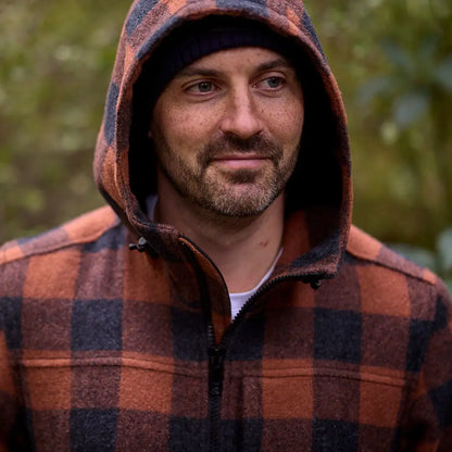 Man wearing a hooded orange and black plaid Swanndri Hudson Wool Hoody with beanie