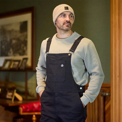Men wearing black dungarees with a light shirt and Swanndri Newton Beanie for a cozy look