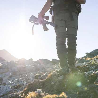 Hiker in country clothing with rifle wearing Swazi Ali Gaiters for outdoor hunting